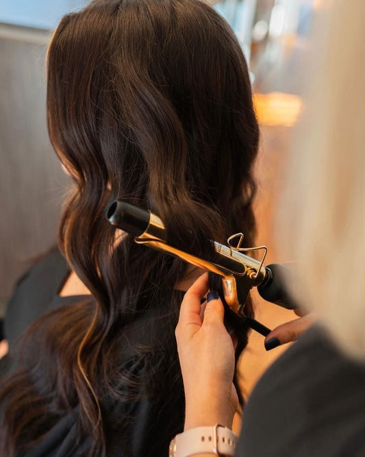 A Hyde Salon stylist styling long dark hair at the Vista location in Columbia SC