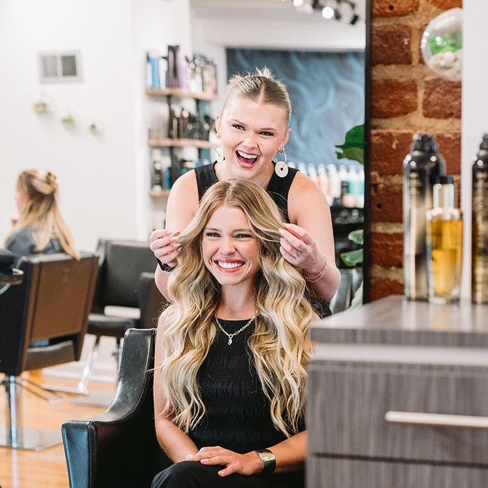 Hyde Salon Vista stylist styling a guest's long blonde waves during a personalized styling session
